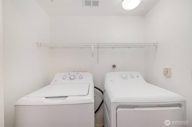 laundry area with washer and dryer, visible vents, and laundry area