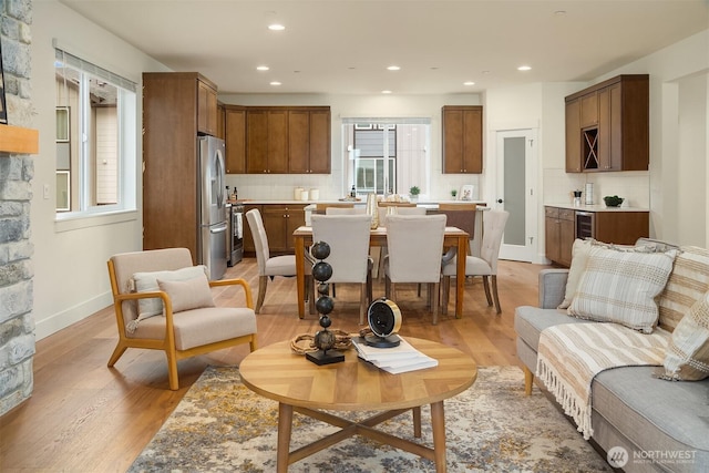 living room featuring recessed lighting, baseboards, a healthy amount of sunlight, and light wood-style flooring