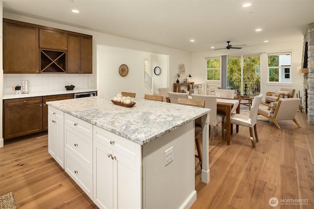 kitchen featuring open floor plan, a center island, light wood-type flooring, and ceiling fan