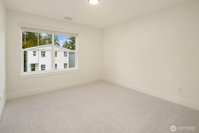 carpeted empty room with visible vents and baseboards