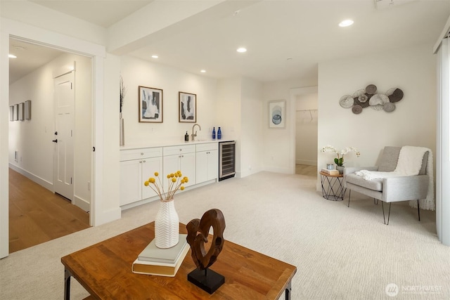 interior space with baseboards, wet bar, recessed lighting, wine cooler, and light colored carpet