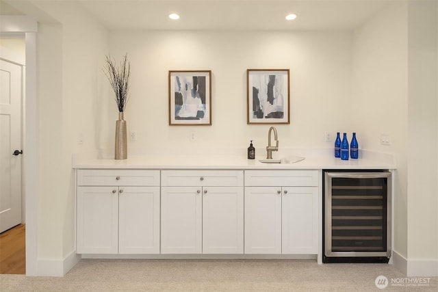 bar featuring beverage cooler, recessed lighting, indoor wet bar, and a sink