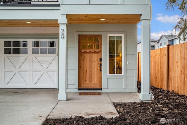 property entrance featuring a garage and fence