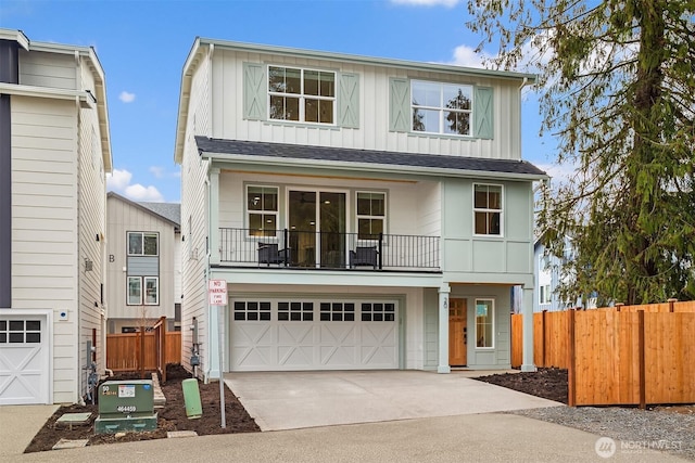 view of front of property featuring board and batten siding, fence, a balcony, a garage, and driveway