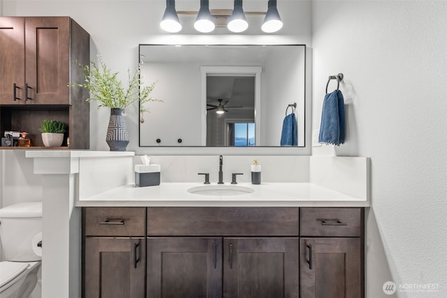 bathroom featuring toilet, vanity, and a ceiling fan