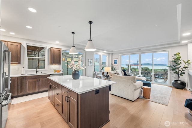 kitchen with a sink, a kitchen island, and light wood finished floors