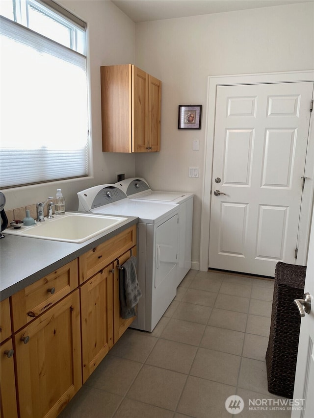 laundry room with light tile patterned floors, a sink, cabinet space, and separate washer and dryer