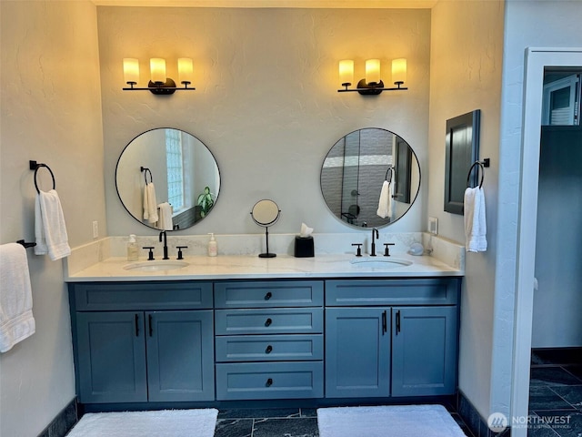 bathroom featuring a sink, baseboards, and double vanity