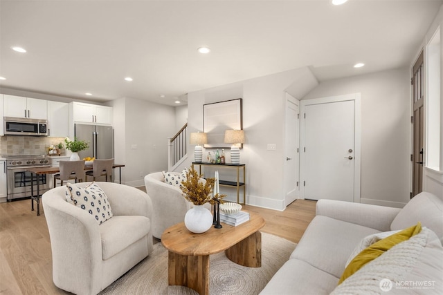 living room featuring stairway, recessed lighting, and light wood-type flooring