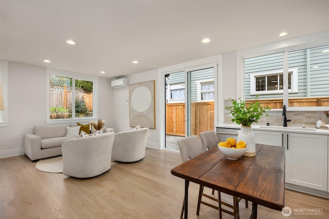 dining room featuring recessed lighting, light wood-style flooring, and a wall mounted AC