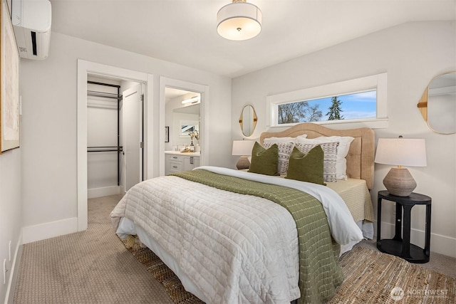 bedroom with a walk in closet, baseboards, a wall mounted air conditioner, carpet floors, and a closet