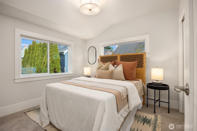 bedroom with lofted ceiling, carpet flooring, and baseboards