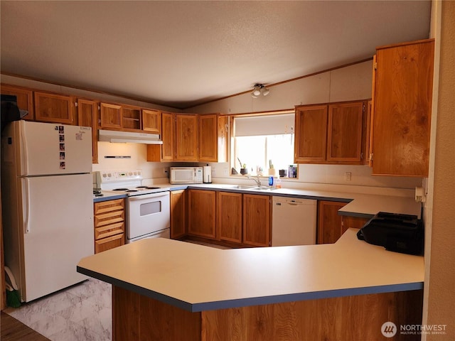 kitchen featuring under cabinet range hood, vaulted ceiling, brown cabinetry, marble finish floor, and white appliances