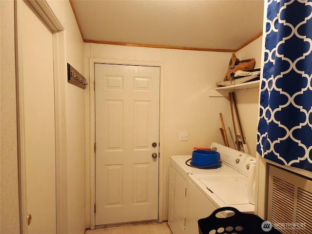 laundry area featuring washing machine and clothes dryer, laundry area, a textured ceiling, and crown molding