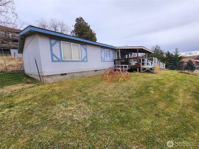 rear view of property with crawl space and a yard