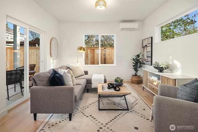 living room with baseboards, wood finished floors, and a wall unit AC