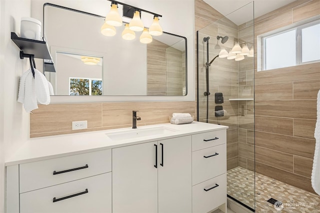 bathroom featuring decorative backsplash, a stall shower, vanity, and tile walls