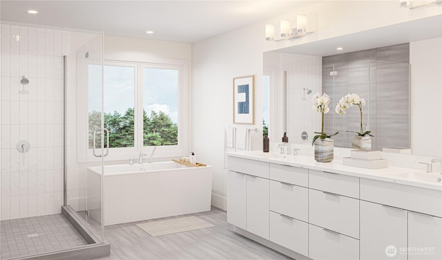 full bath with a sink, recessed lighting, a shower stall, double vanity, and a freestanding bath