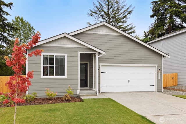 view of front of home with a garage, concrete driveway, a front lawn, and fence