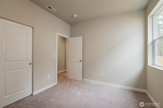 unfurnished bedroom featuring carpet flooring, visible vents, and baseboards