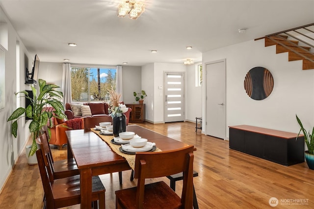 dining room featuring light wood-type flooring and stairs