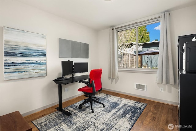 home office featuring wood finished floors, visible vents, and baseboards