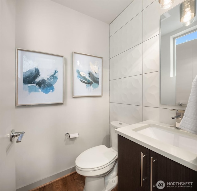 bathroom featuring vanity, toilet, and wood finished floors