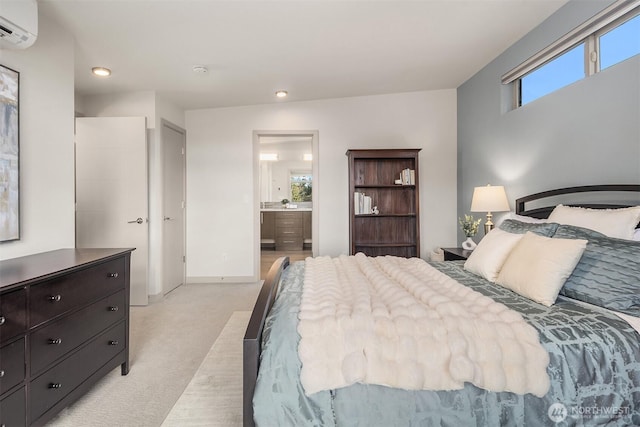 bedroom featuring baseboards, light colored carpet, recessed lighting, ensuite bathroom, and a wall mounted AC