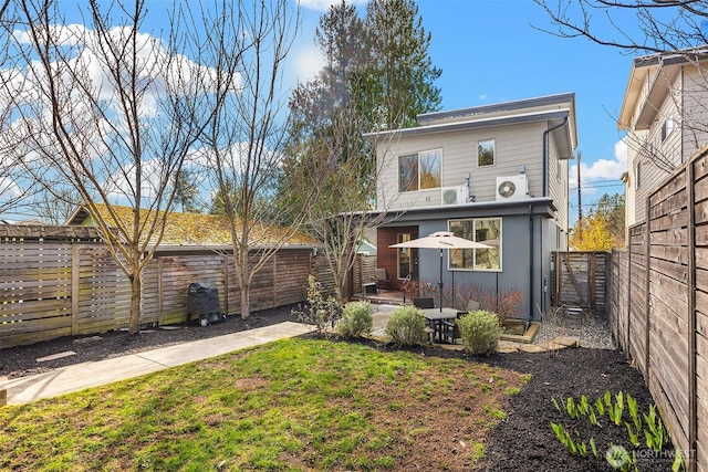 back of house with a lawn and a fenced backyard