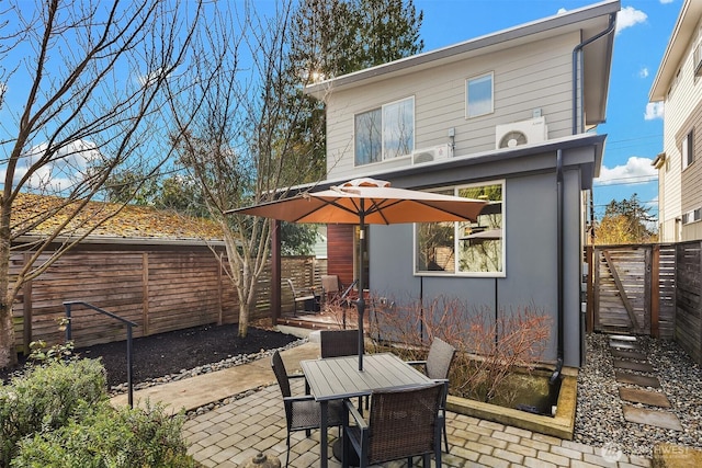 back of house with outdoor dining area, a patio area, and a fenced backyard