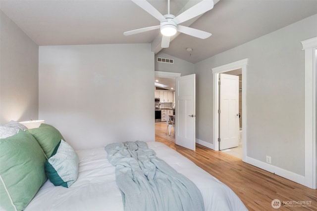 bedroom featuring visible vents, vaulted ceiling with beams, baseboards, ceiling fan, and light wood-style flooring