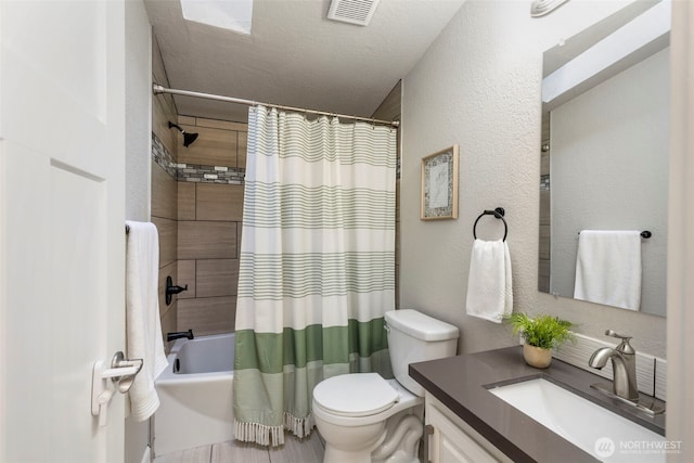 full bathroom featuring vanity, visible vents, shower / tub combo, toilet, and a textured wall