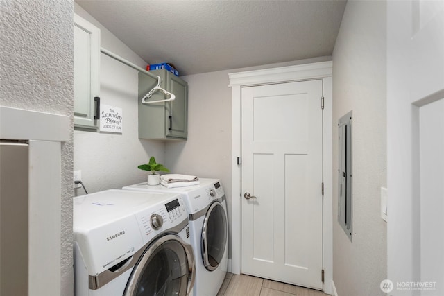 clothes washing area with cabinet space, washing machine and dryer, and a textured ceiling