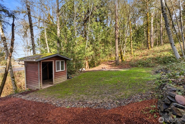 view of yard featuring an outdoor structure and a forest view