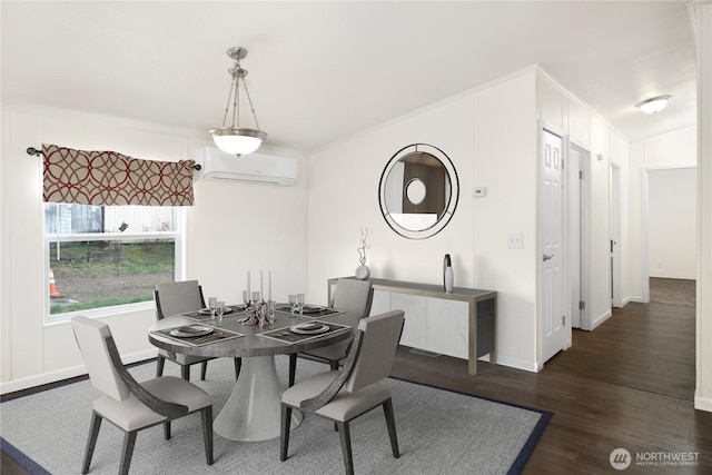 dining room with a wall mounted air conditioner, baseboards, and wood finished floors