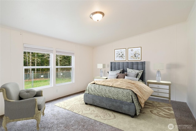 carpeted bedroom featuring a decorative wall and vaulted ceiling