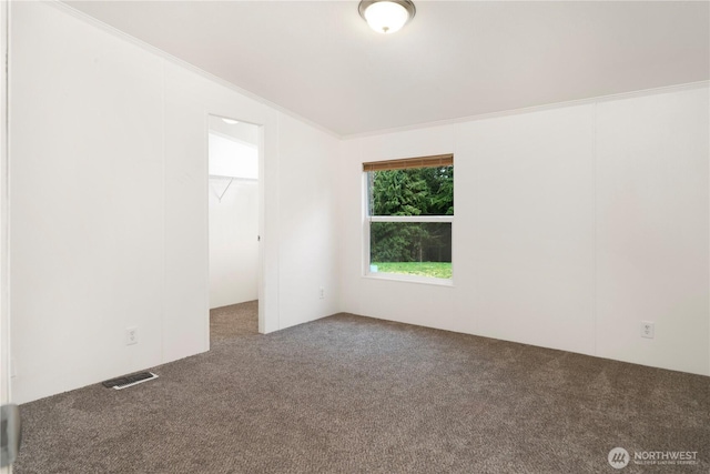 carpeted spare room featuring visible vents and crown molding