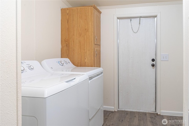 laundry area featuring baseboards, cabinet space, independent washer and dryer, and wood finished floors