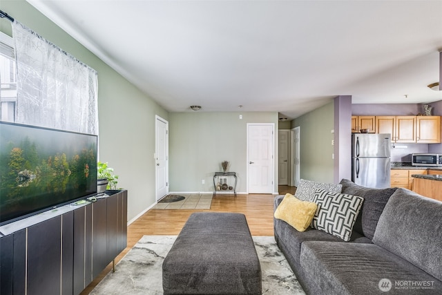 living area featuring baseboards and light wood-style floors