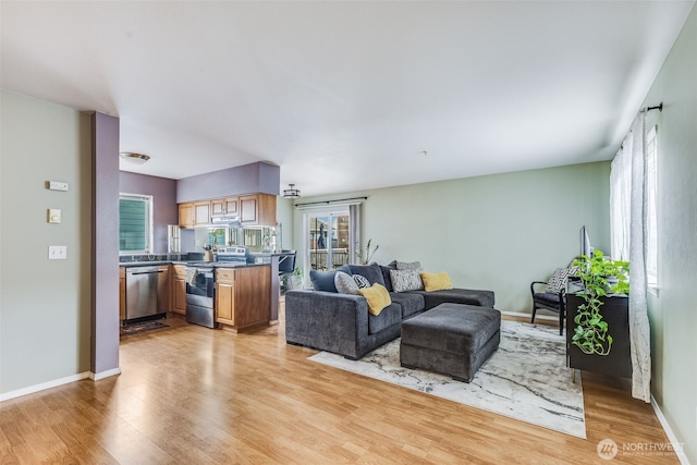 living area with light wood-style flooring and baseboards