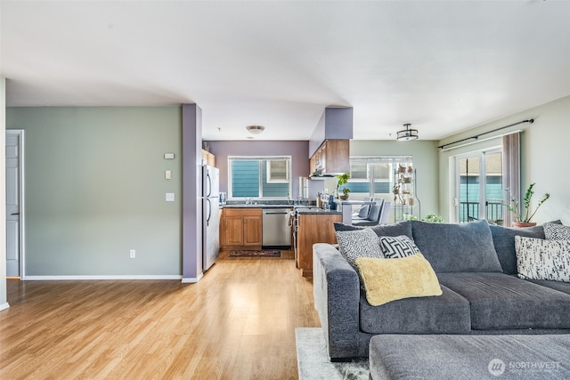 living area featuring baseboards and light wood-type flooring