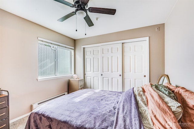 carpeted bedroom featuring a baseboard radiator, baseboards, a closet, and a ceiling fan