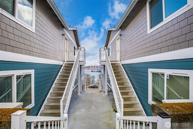 view of property exterior featuring stairs and a water view