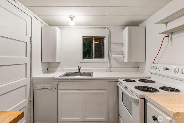 kitchen featuring white appliances, light countertops, open shelves, and a sink