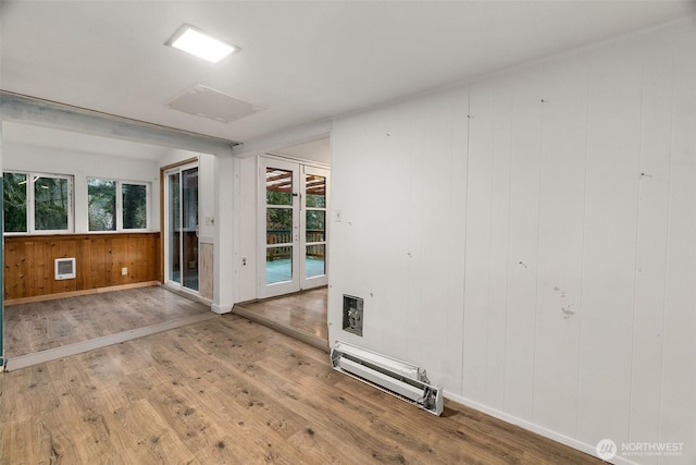 unfurnished room featuring a wealth of natural light, baseboards, and wood finished floors