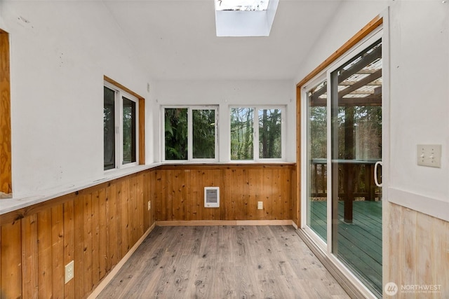 unfurnished sunroom with a skylight