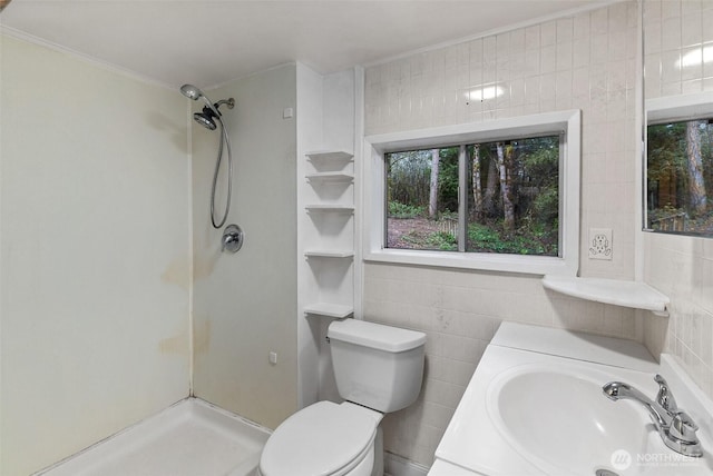 full bathroom with vanity, toilet, tile walls, and walk in shower