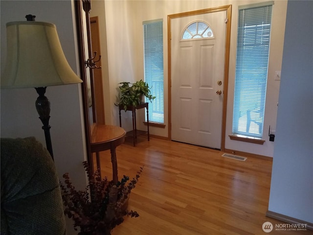 foyer featuring visible vents, light wood-type flooring, and baseboards