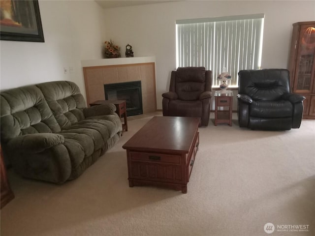 living area with a tiled fireplace and light colored carpet