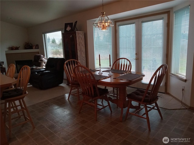 dining area with a chandelier, a fireplace, and baseboards